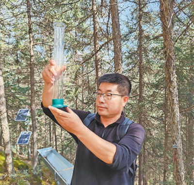 敬文茂在观测降水情况。 本报记者 宋朝军摄